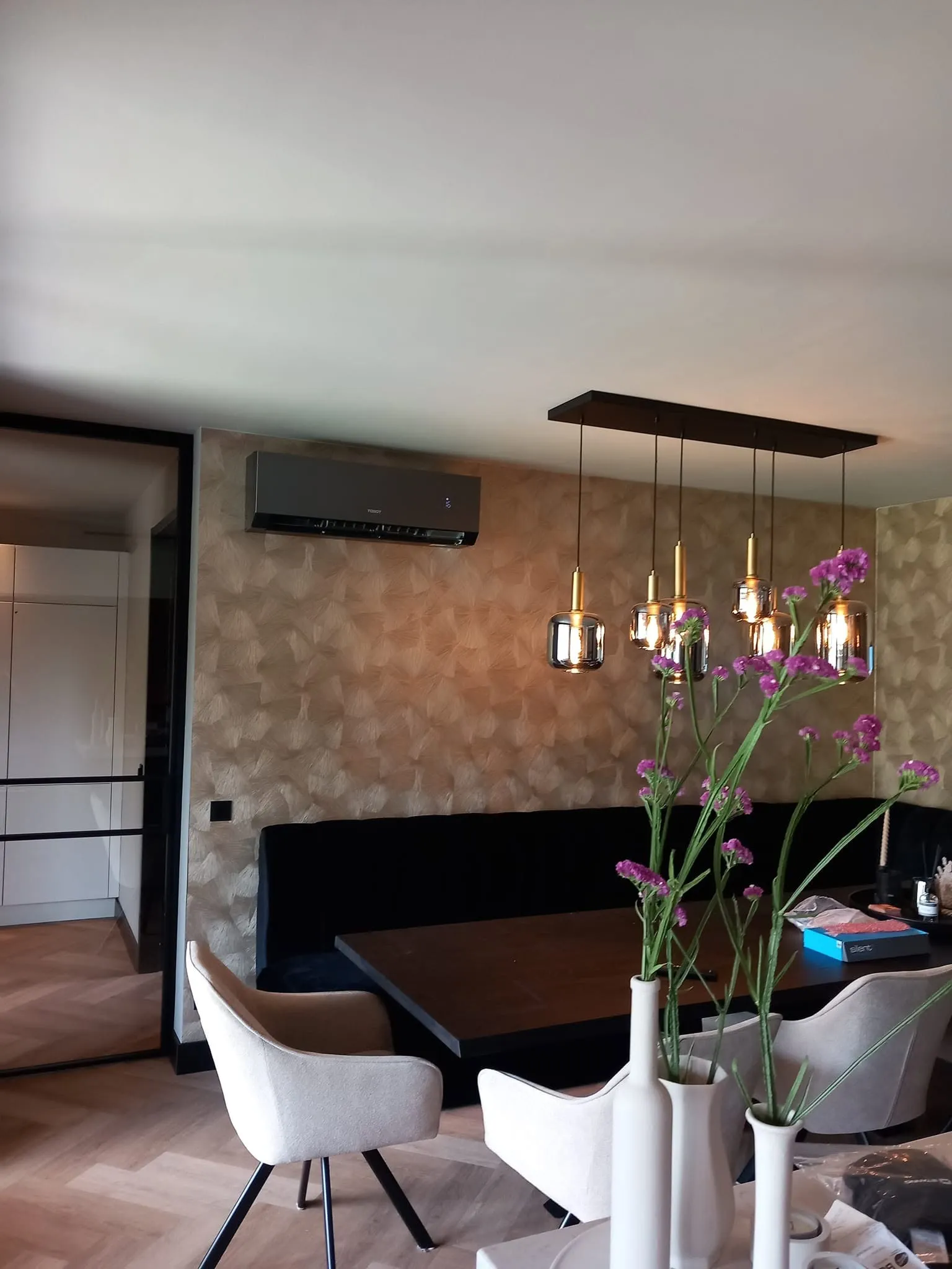Zwarte airco wandunit strak weggewerkt in een moderne eetkamer